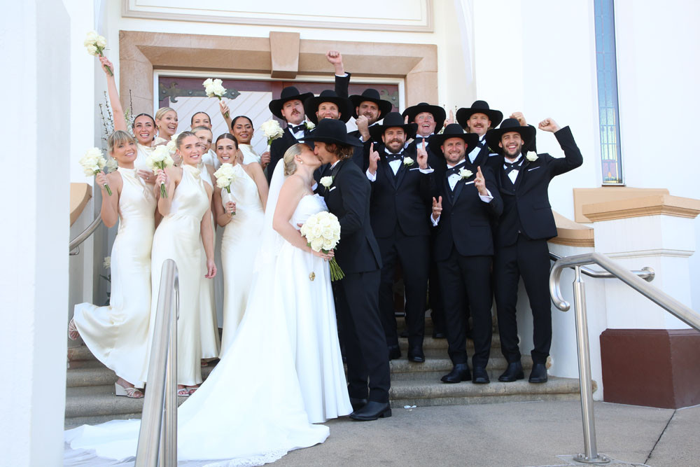 The newly married couple share a kiss in front of their jubilant bridal party. Picture: Maria Girgenti