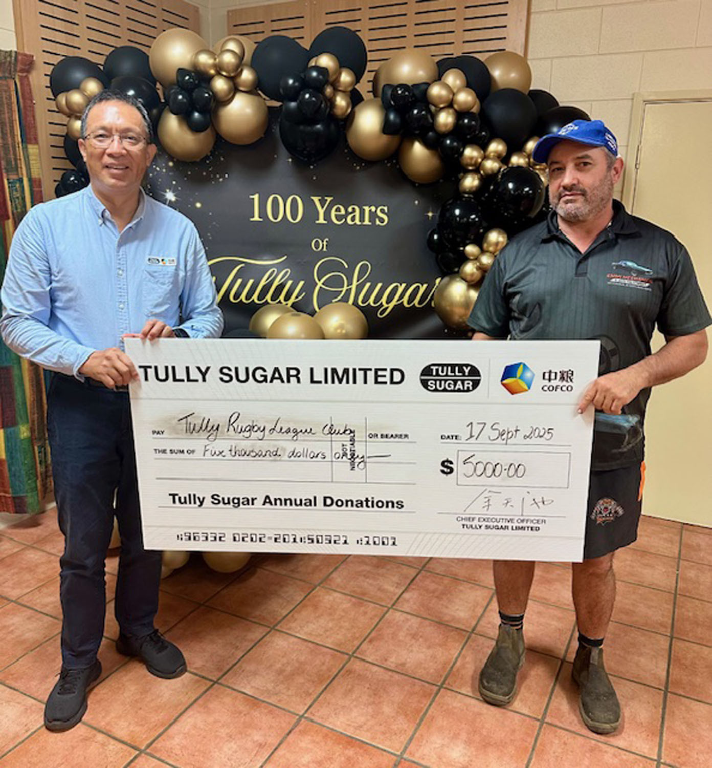 COFCO’s chief executive officer Andrew Yu (left) with Anthony Emmi president of the Tully Tigers Rugby League Football Club which received a donation of $500. Pictures: Supplied